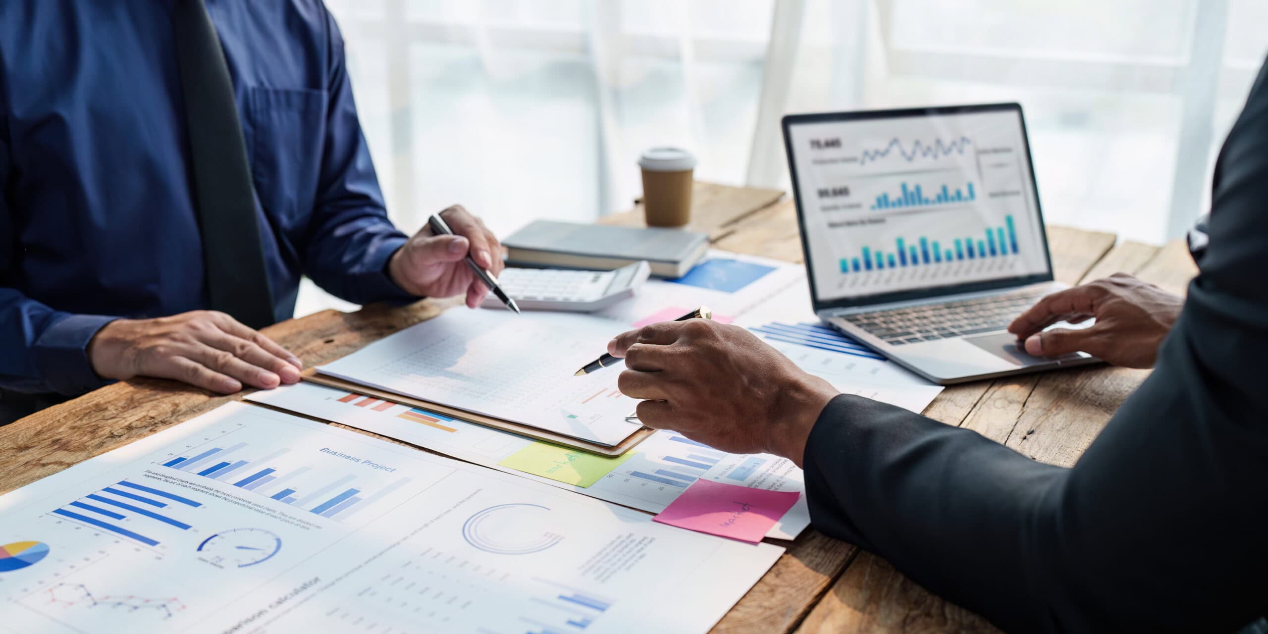 Team arbeitet gemeinsam mit Diagrammen und Unterlagen zur Analyse und Planung