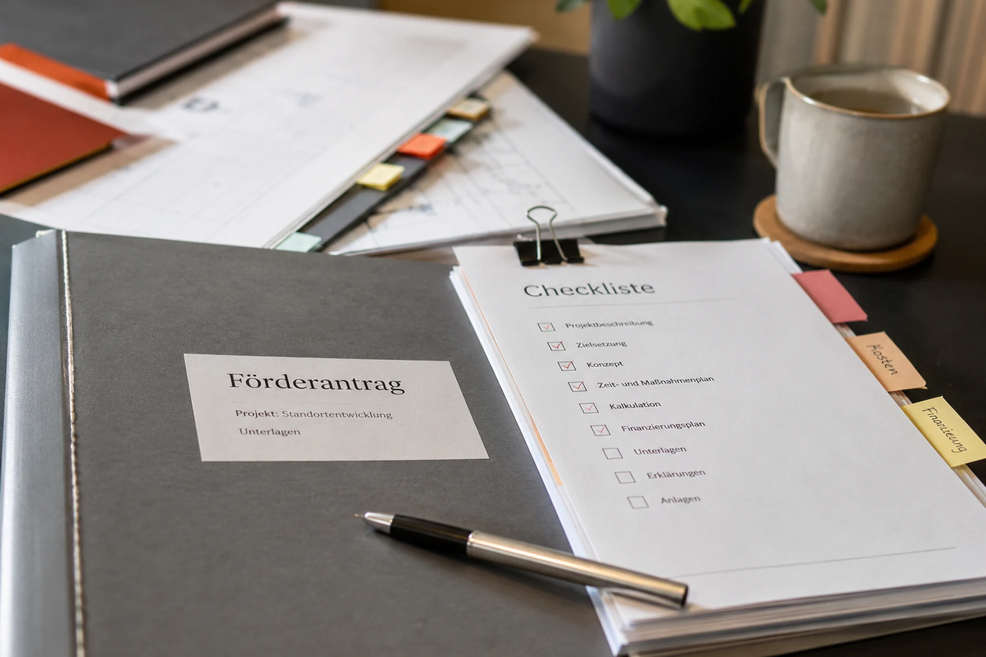 Förderantrag und Checkliste mit geordneten Unterlagen auf einem Schreibtisch